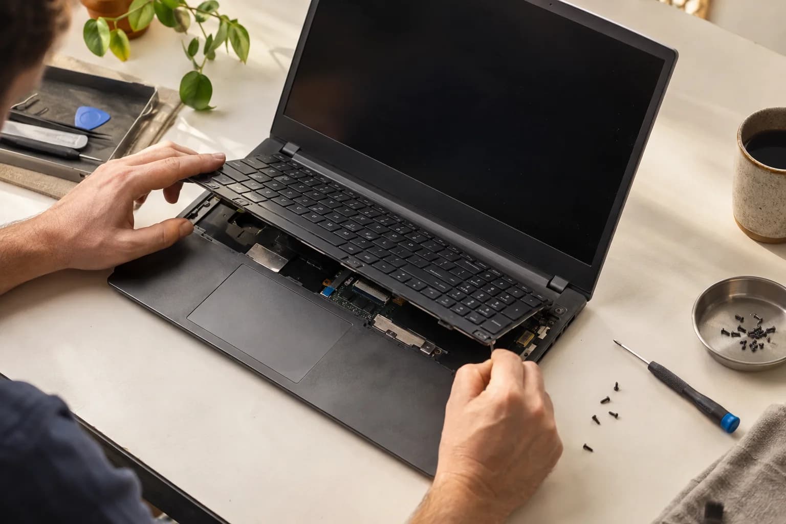Concept image of a worn laptop being carefully repaired on a workbench